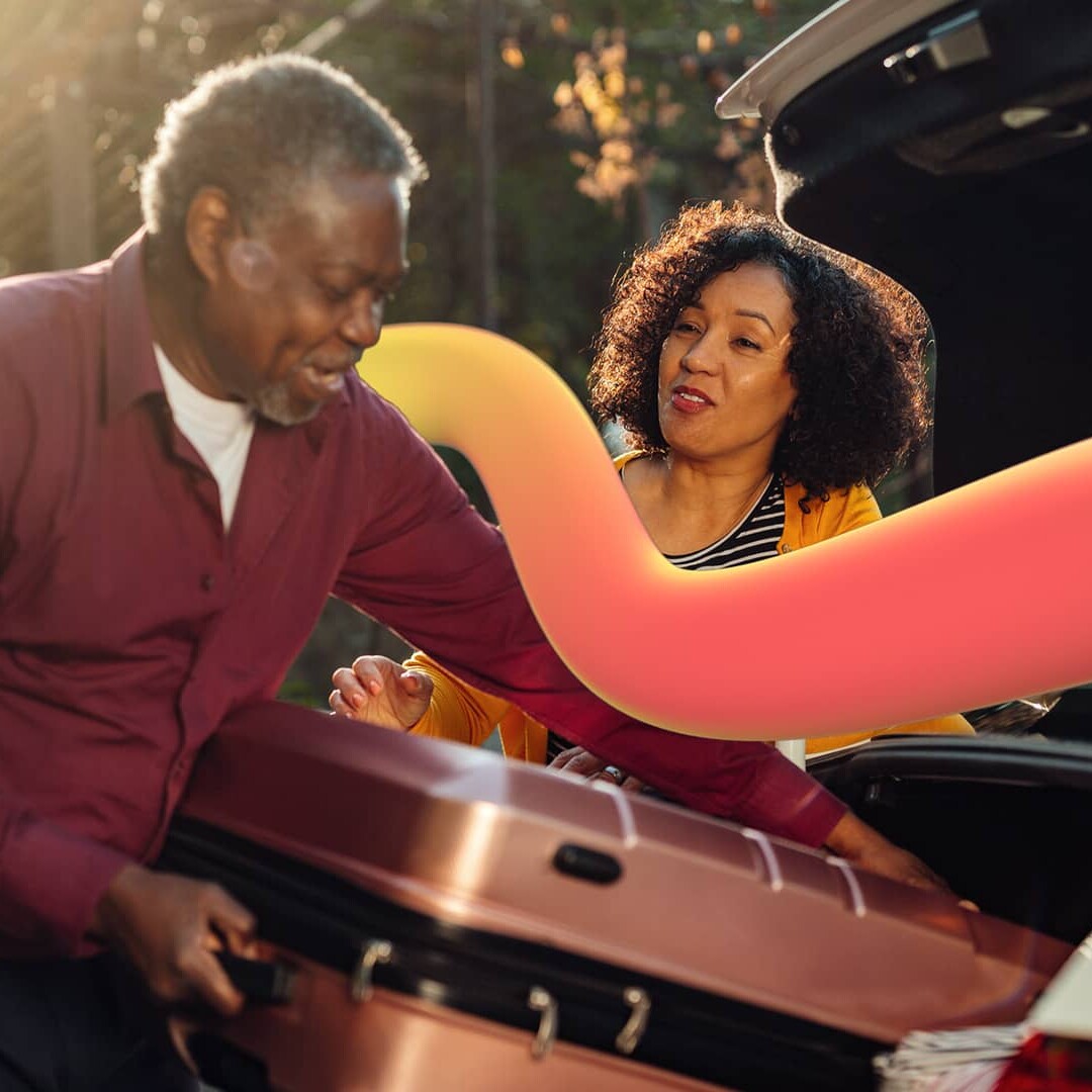 Woman speaking to the man during suitcase loading in a car trunk