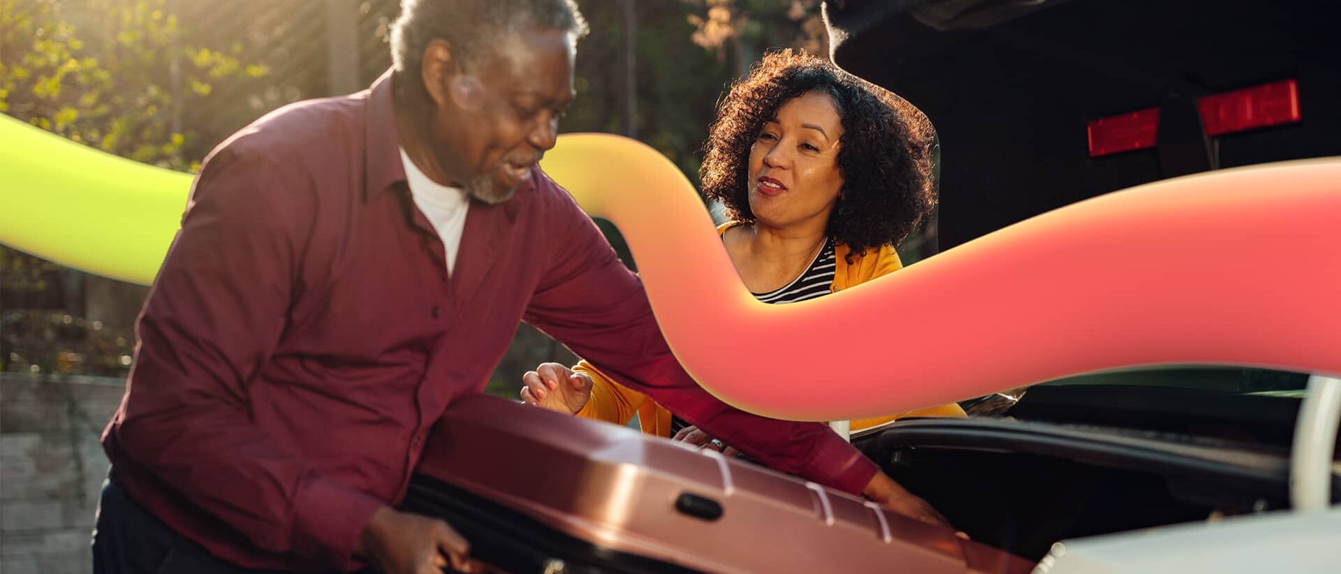 Woman speaking to the man during suitcase loading in a car trunk