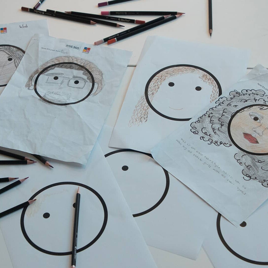 Hairmojis sketches and pencils on a table