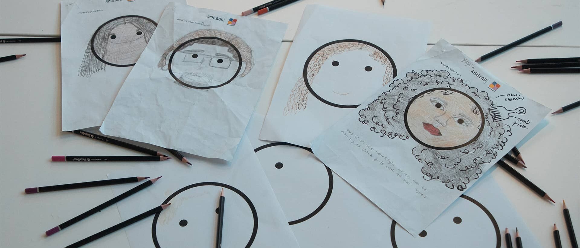 Hairmojis sketches and pencils on a table