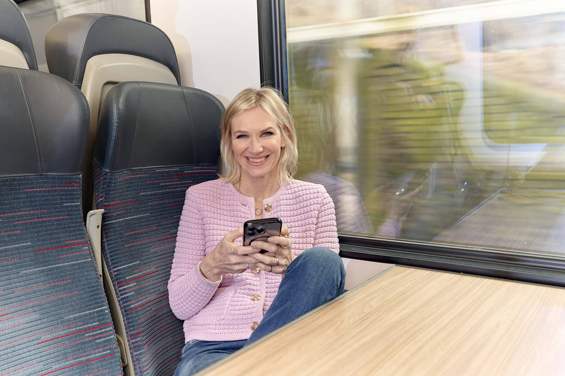 Woman on train holding the mobile phone