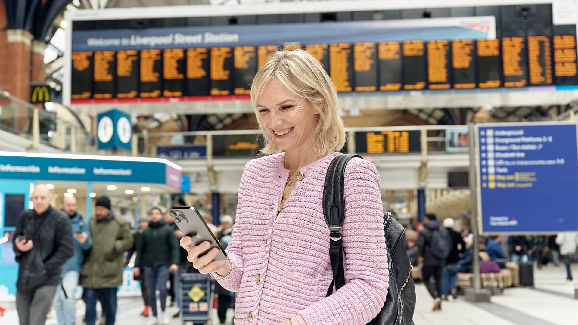 Woman at terminal looking at the mobile phone