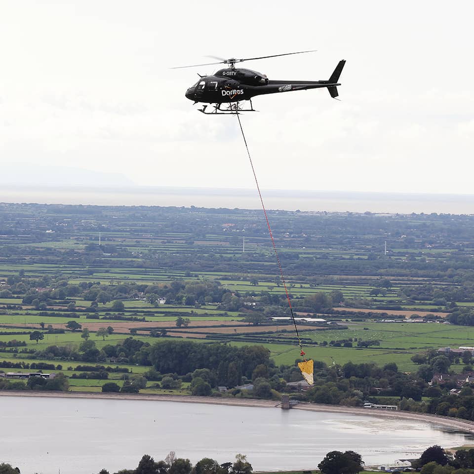 Helicopter pulling huge piece of nachos over the lake