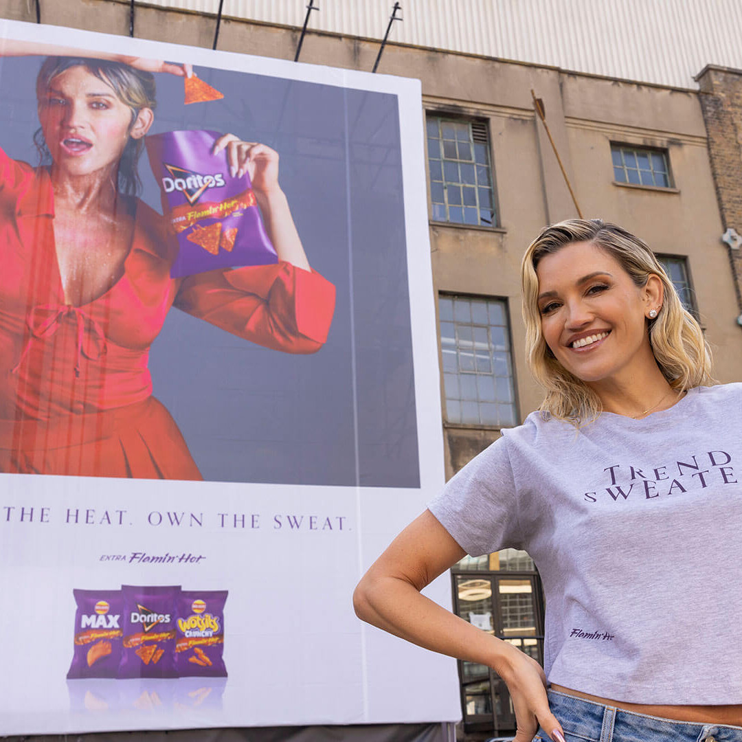 Ashley Roberts in front of a billboard